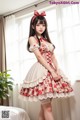 A woman in a red and white dress posing for a picture.