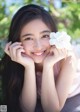 A young woman holding a white flower in her hand.