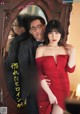 a woman in a red dress standing next to a man in a tuxedo