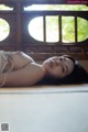 A woman laying on the floor in a white lingerie.