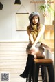 A woman sitting on a stool in a room.