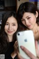 Two young women taking a selfie with their cell phone.