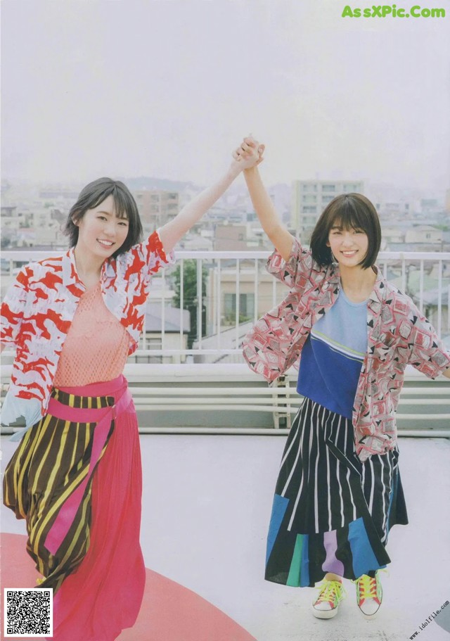 A couple of women standing next to each other on top of a roof.