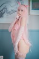 A woman with long pink hair wearing a pink lingerie.